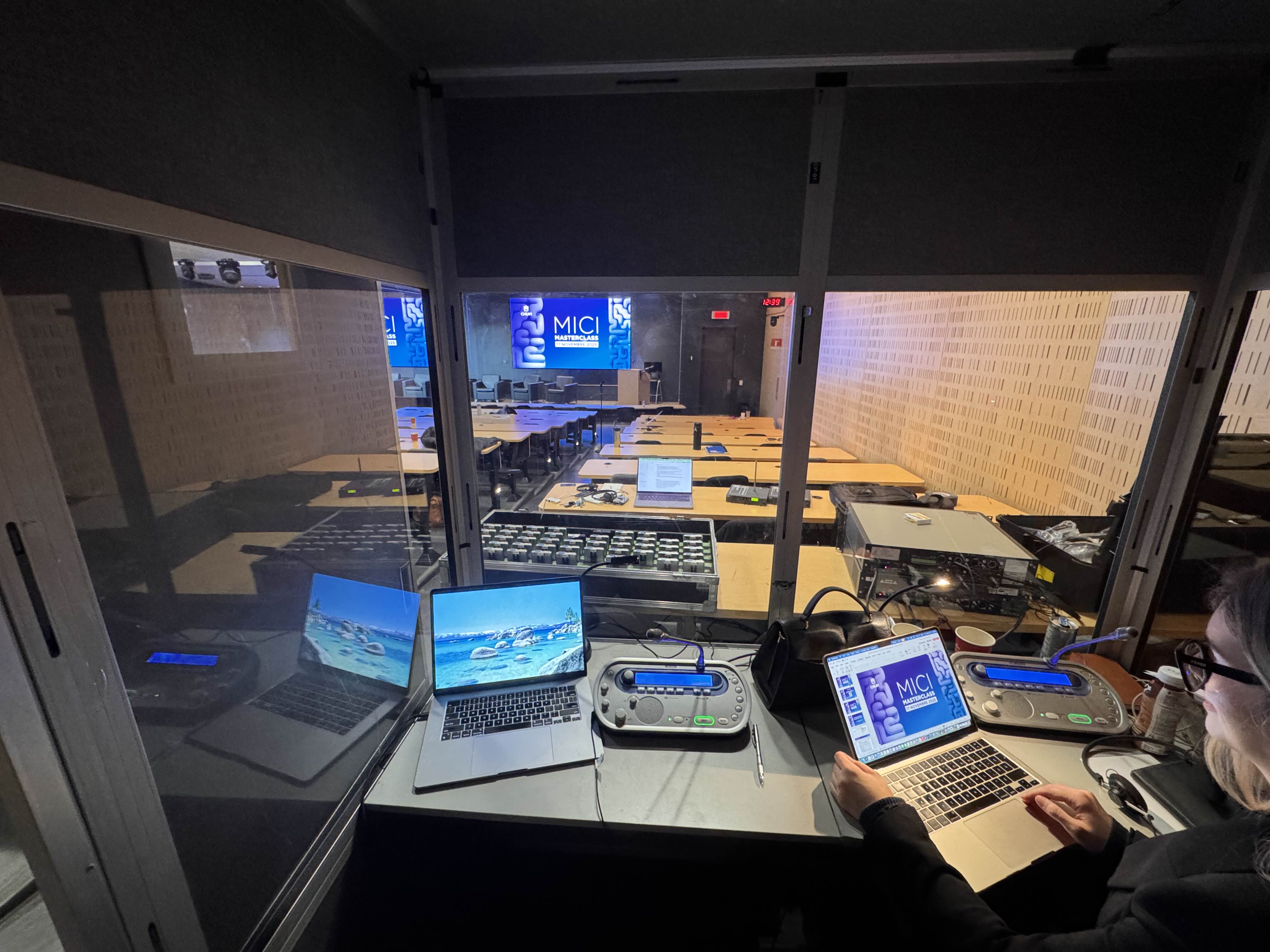 Vue depuis la cabine d'interprétation — interprète en pleine prestation